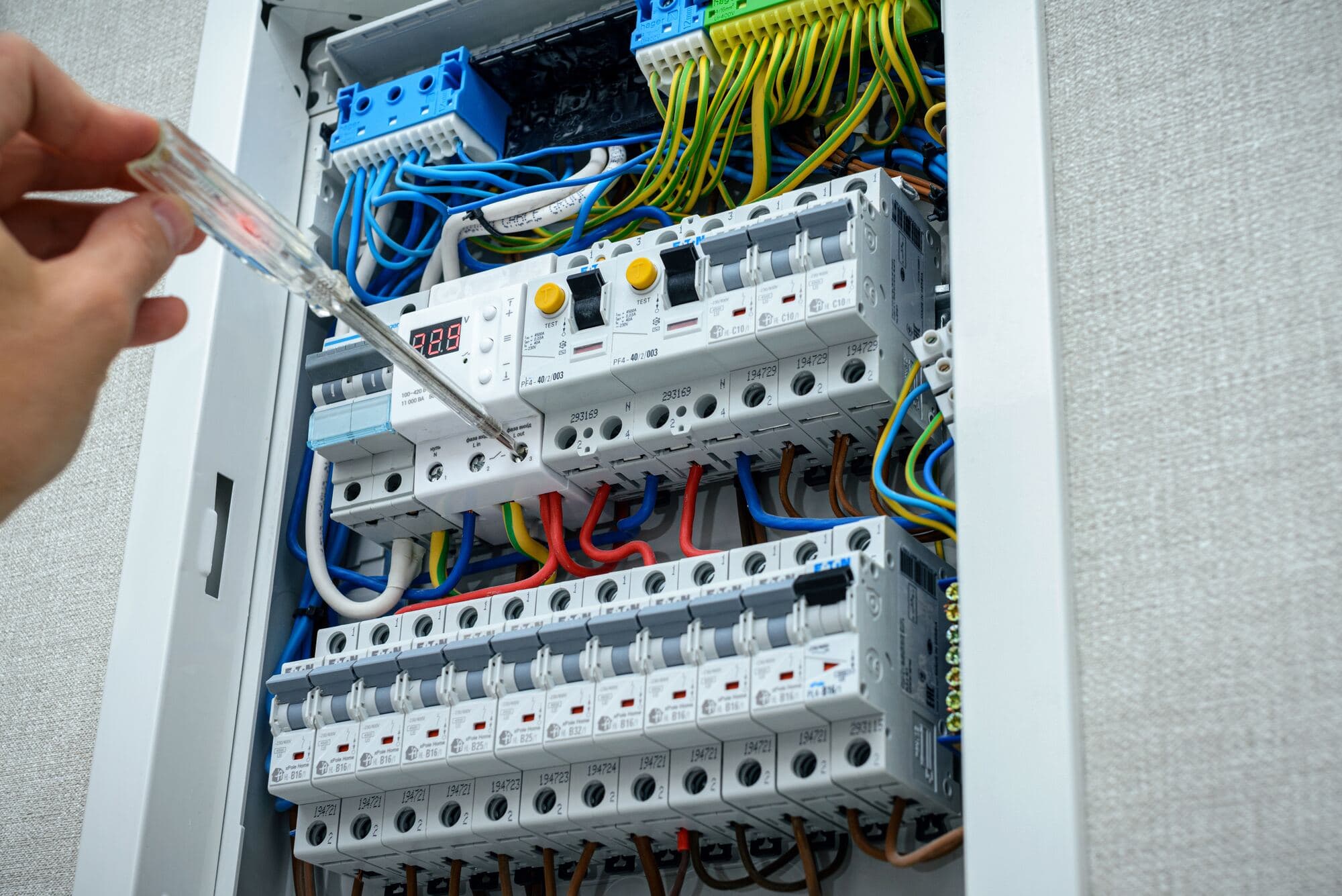 Elektriker kontrollerar en elcentral med spänningsprovare